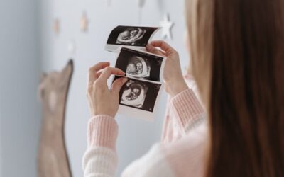 Expectant mother cradling her baby bump, illustrating comfortable pregnancy waxing